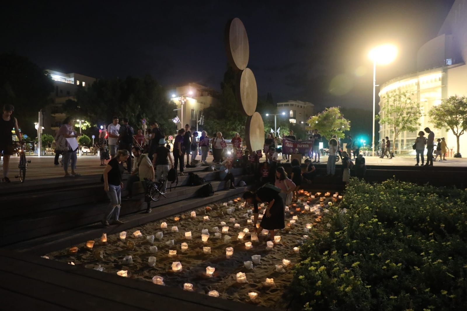 نشطاء عرب ويهود يضيؤون الشموع لذكرى ضحايا الجريمة والعنف في المجتمع العربي في ميدان هبيماه في تل أبيب.-2