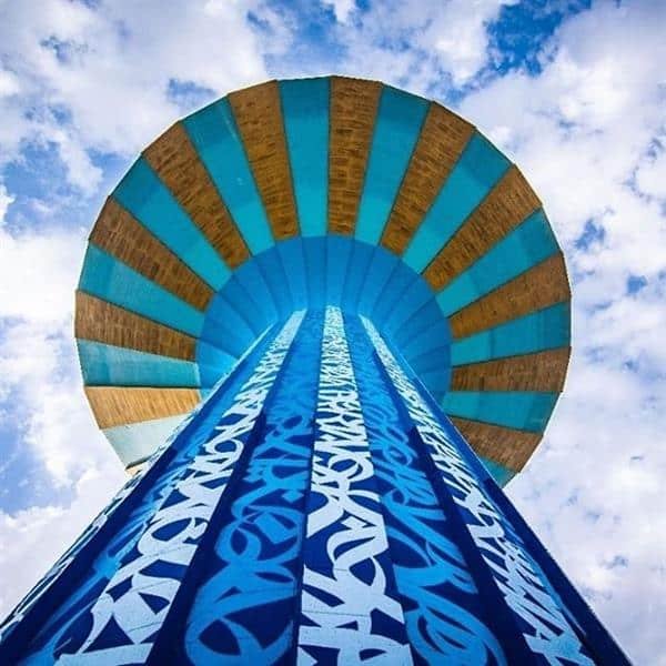 فنان يرسم لوحة فنية بالخط العربي على برج مياه الرياض-0